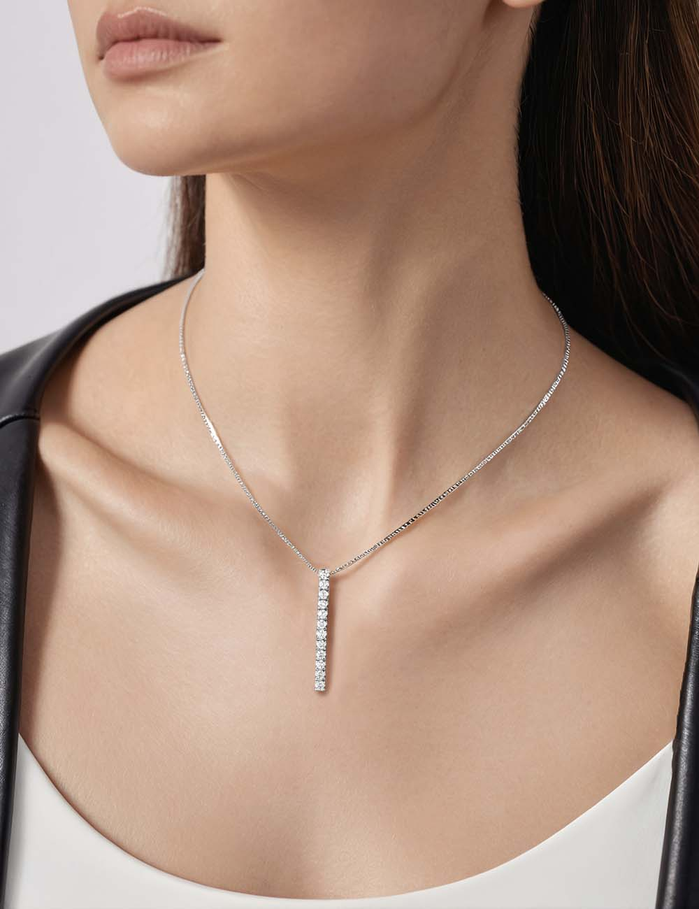 Women's gold pendant with a vertical line of 12 white diamonds in a delicate channel setting, handcrafted in France.