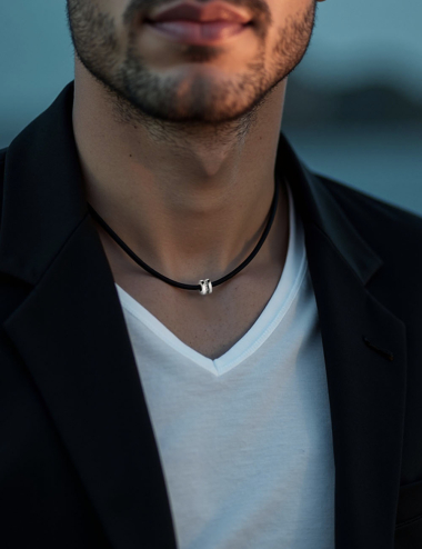 Men's Sense of Light pendant in gold with black diamonds, a refined, contemporary piece on a black cord.