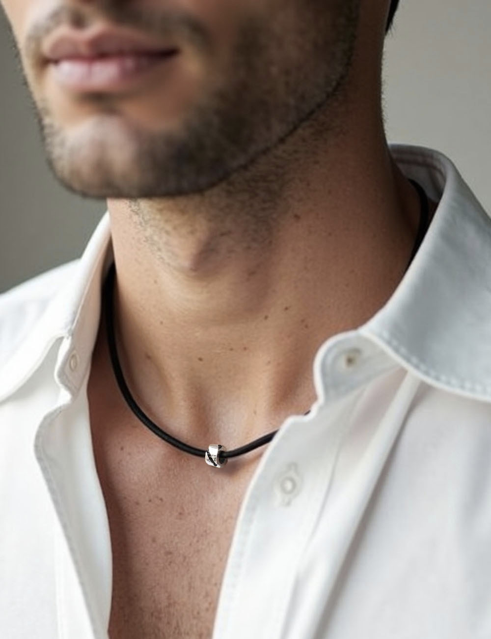 Pendentif homme or blanc et diamants noirs sur cordon noir.