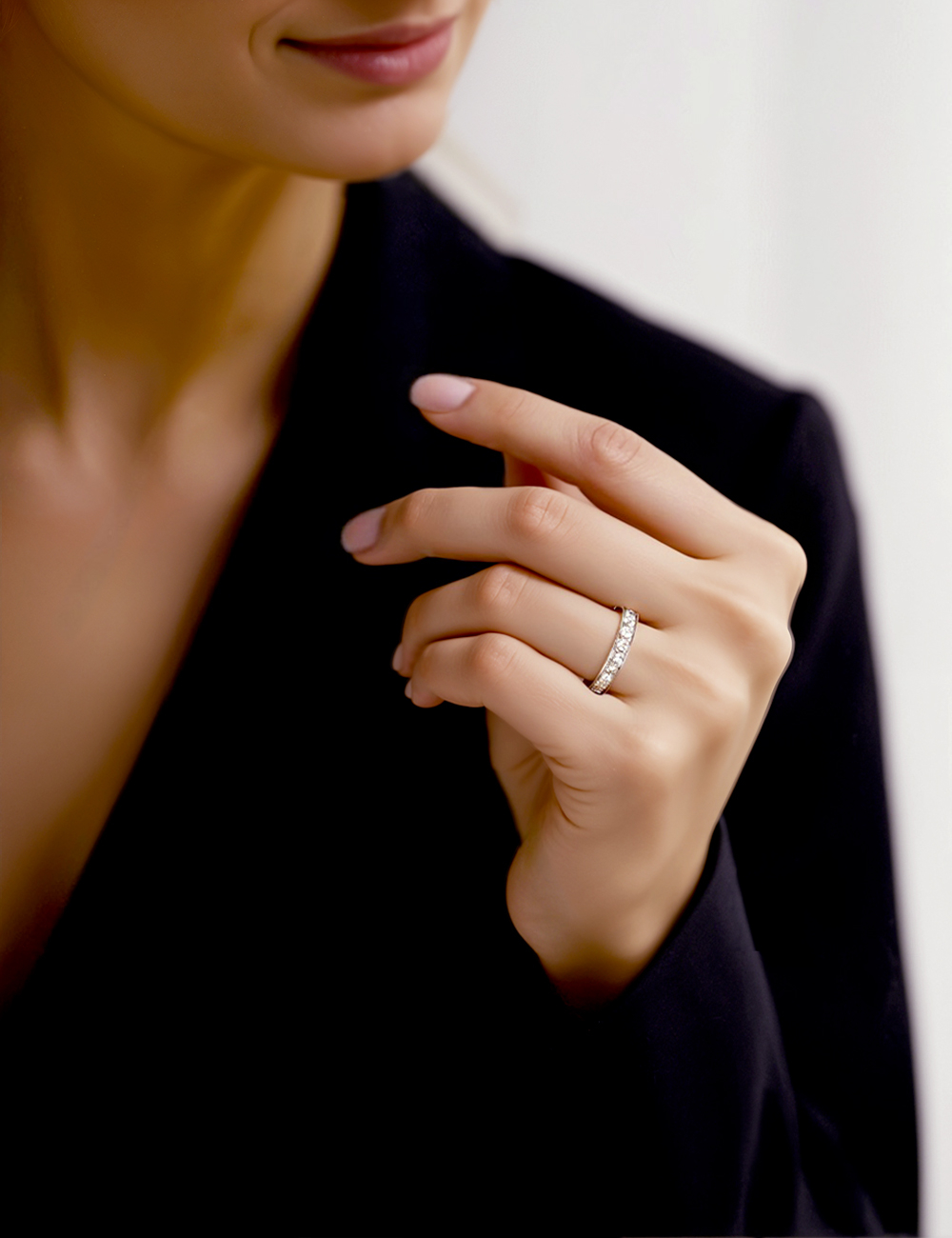 Main féminine portant une alliance en platine avec diamants blancs sertis grains, dans un style élégant et épuré.